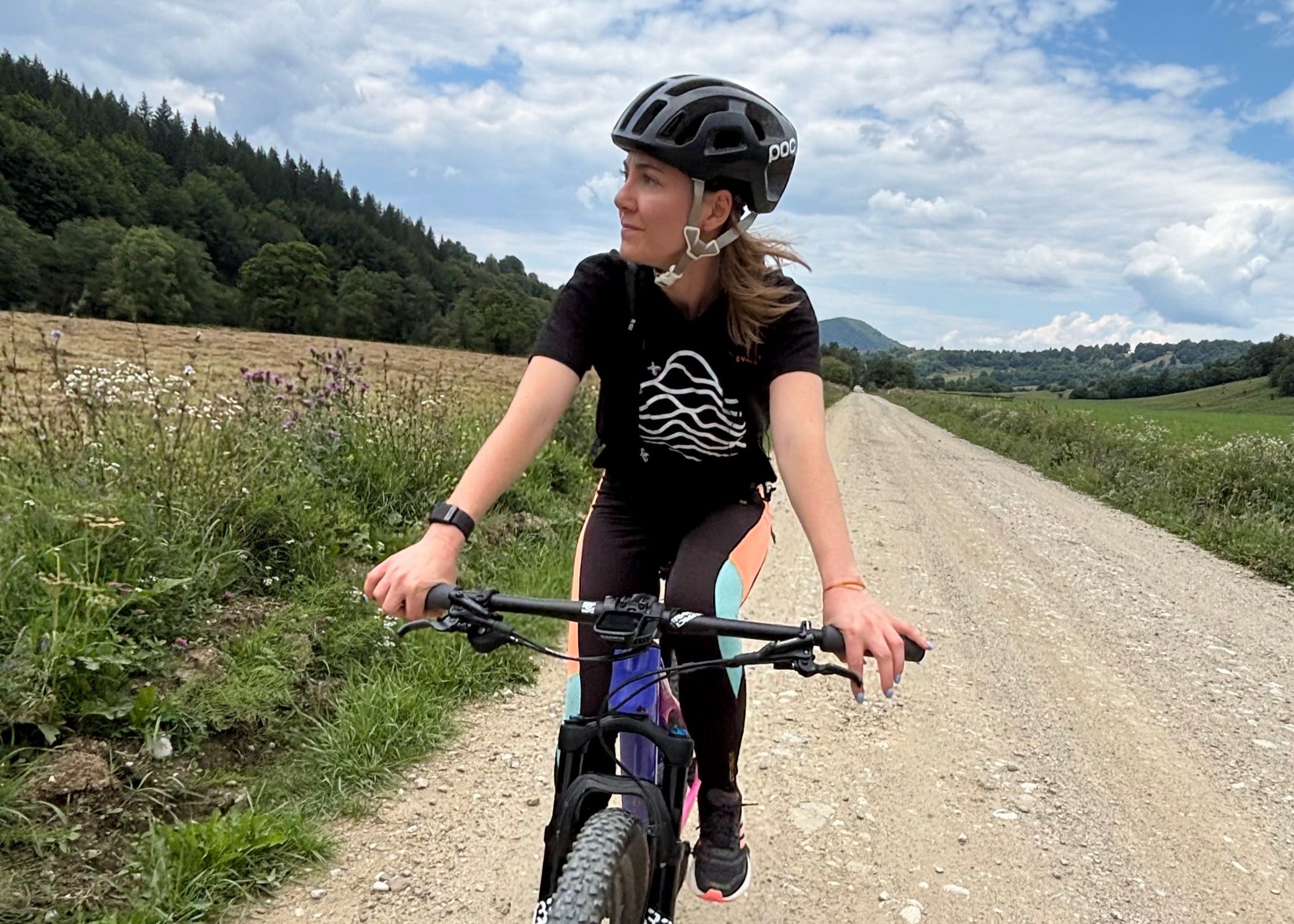 Person riding a bicycle on a dirt road with a scenic background
