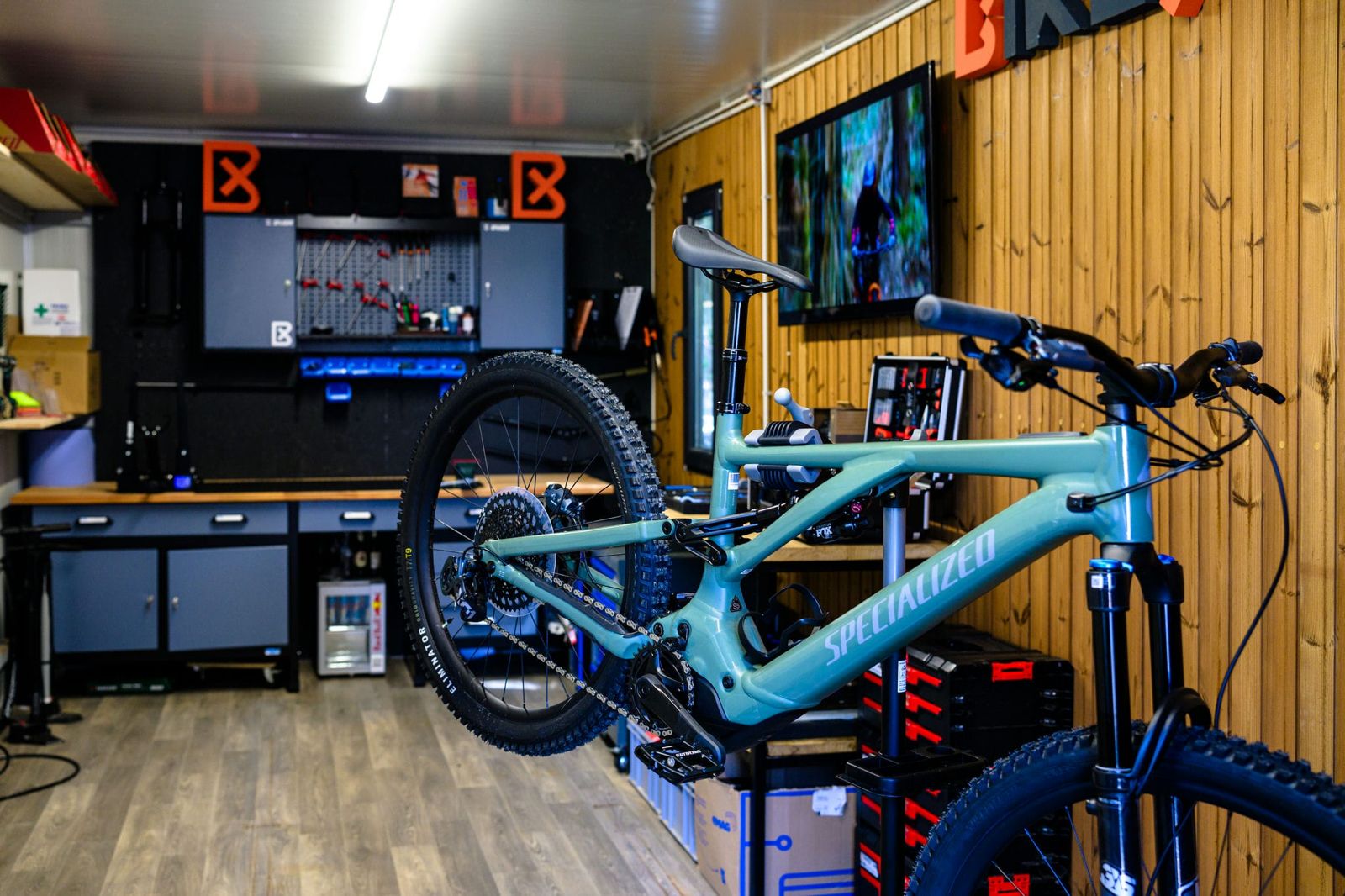 Bicycle frame with 'Specialized' branding in a workshop setting.